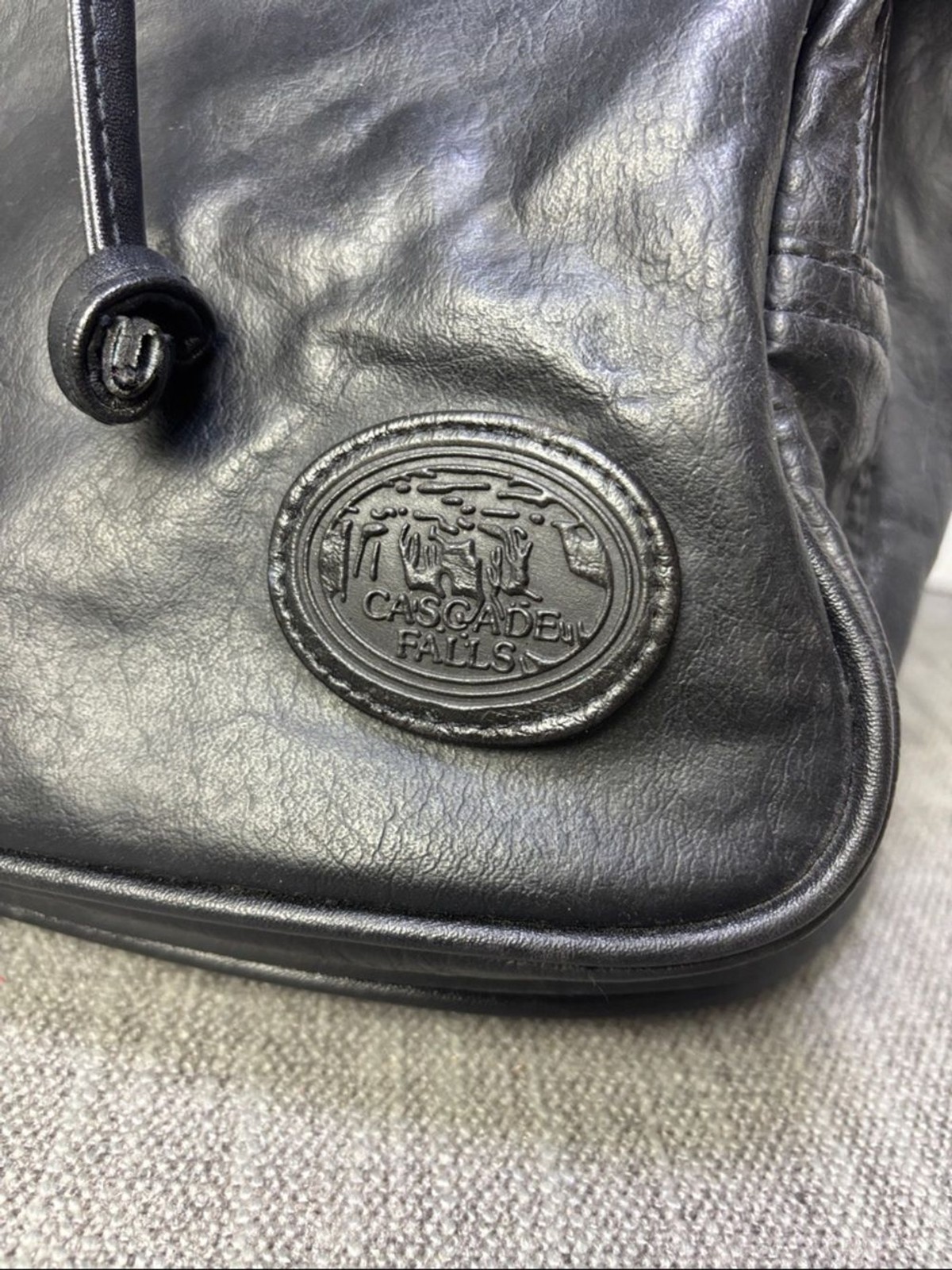Tandem Black Leather Drawstring Backpack with Buckled Flap Cascade Falls