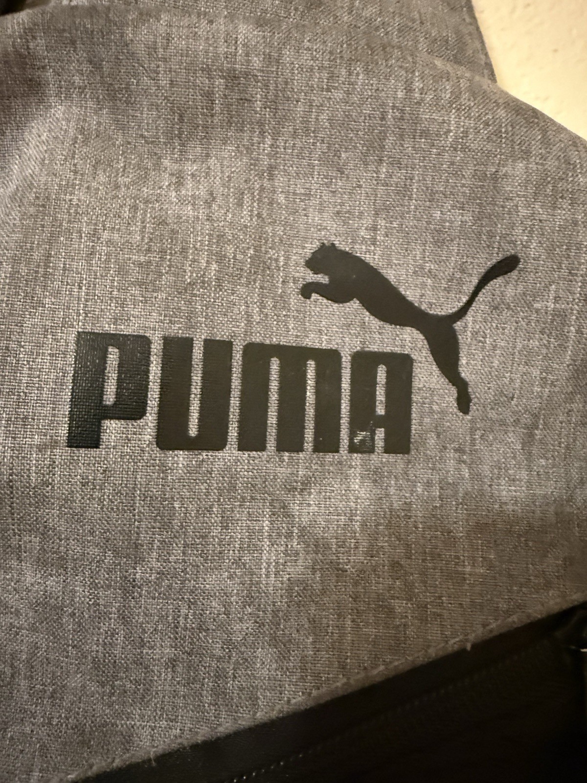 Puma Evercat Sidewall Sling Backpack in black and heather grey.