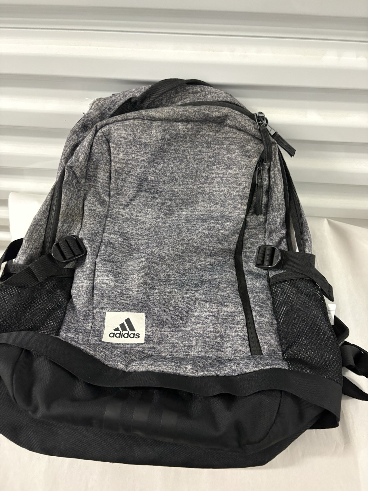 Adidas Defender backpack in grey heather material with black accents.