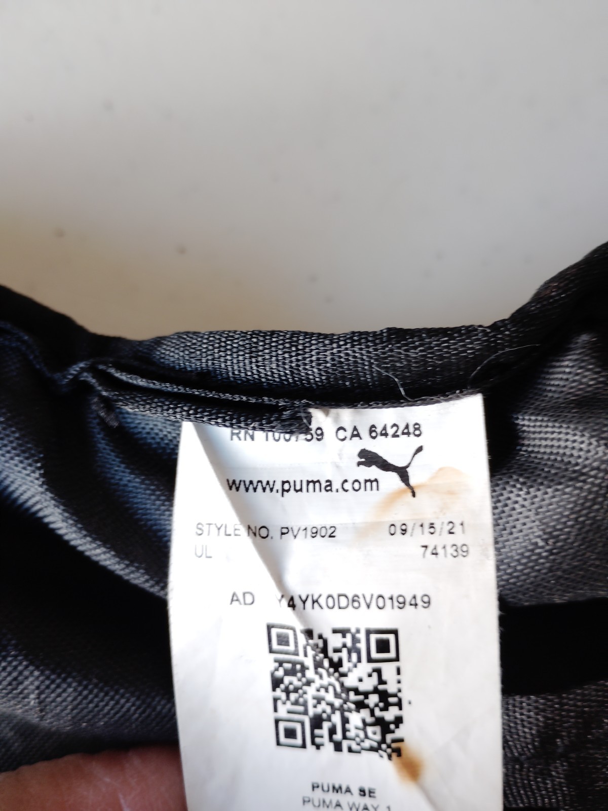 Black PUMA Evercat Equinox cinch bag with a front zippered pocket and mesh side