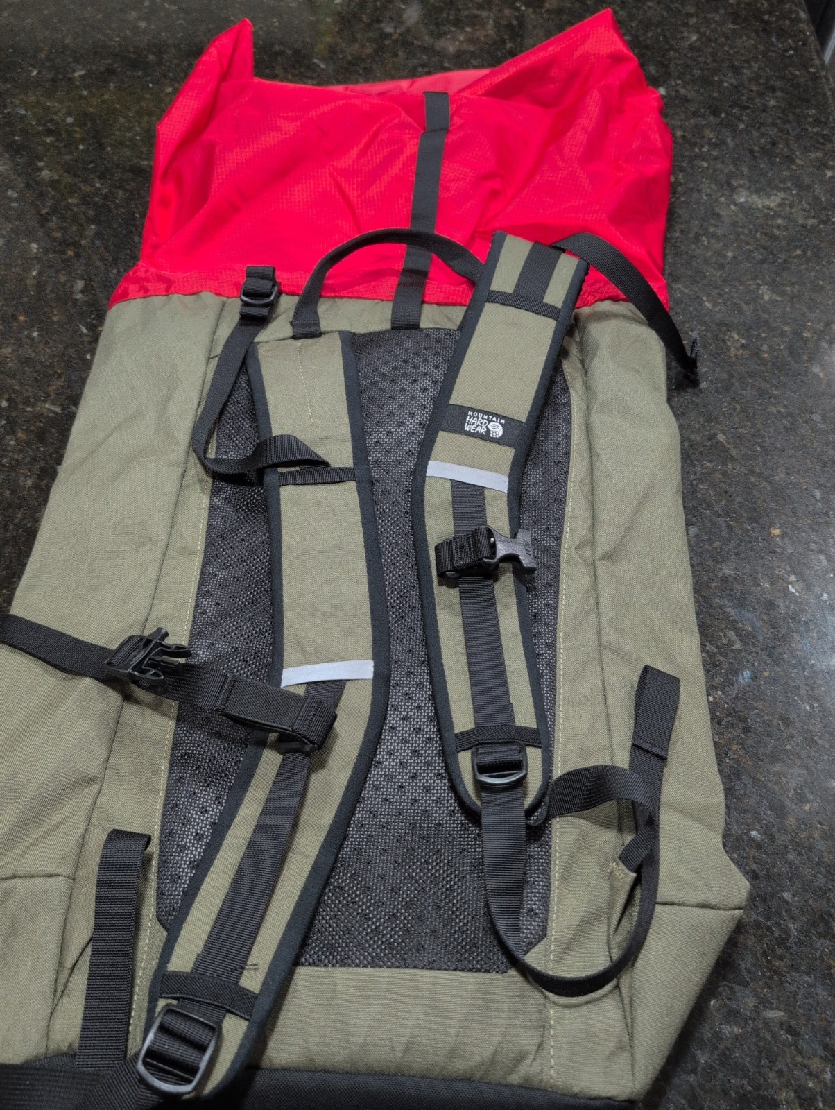 Mountain Hardwear Grotto backpack in an olive green and bright red colorway.