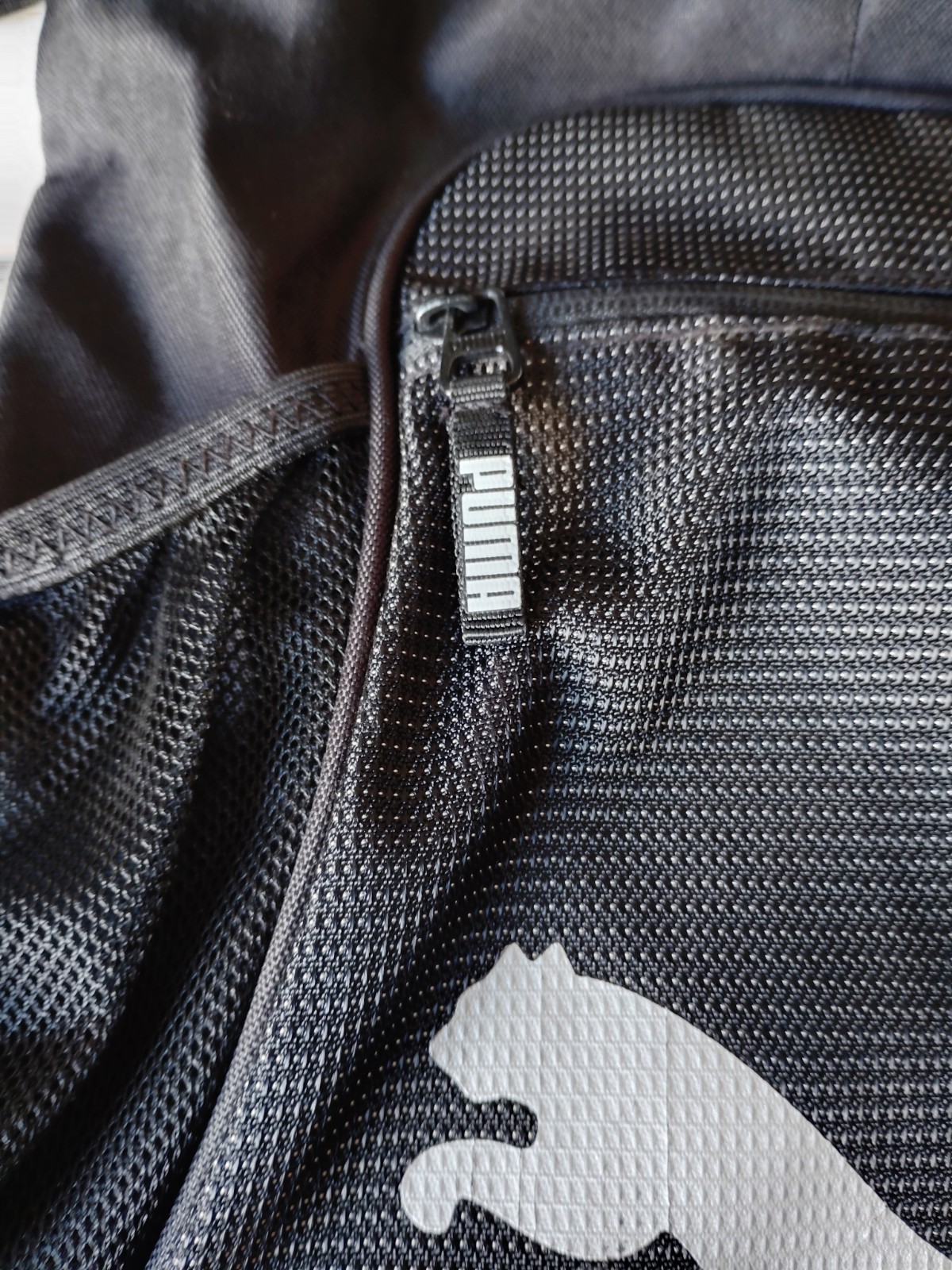 Black PUMA Evercat Equinox cinch bag with a front zippered pocket and mesh side