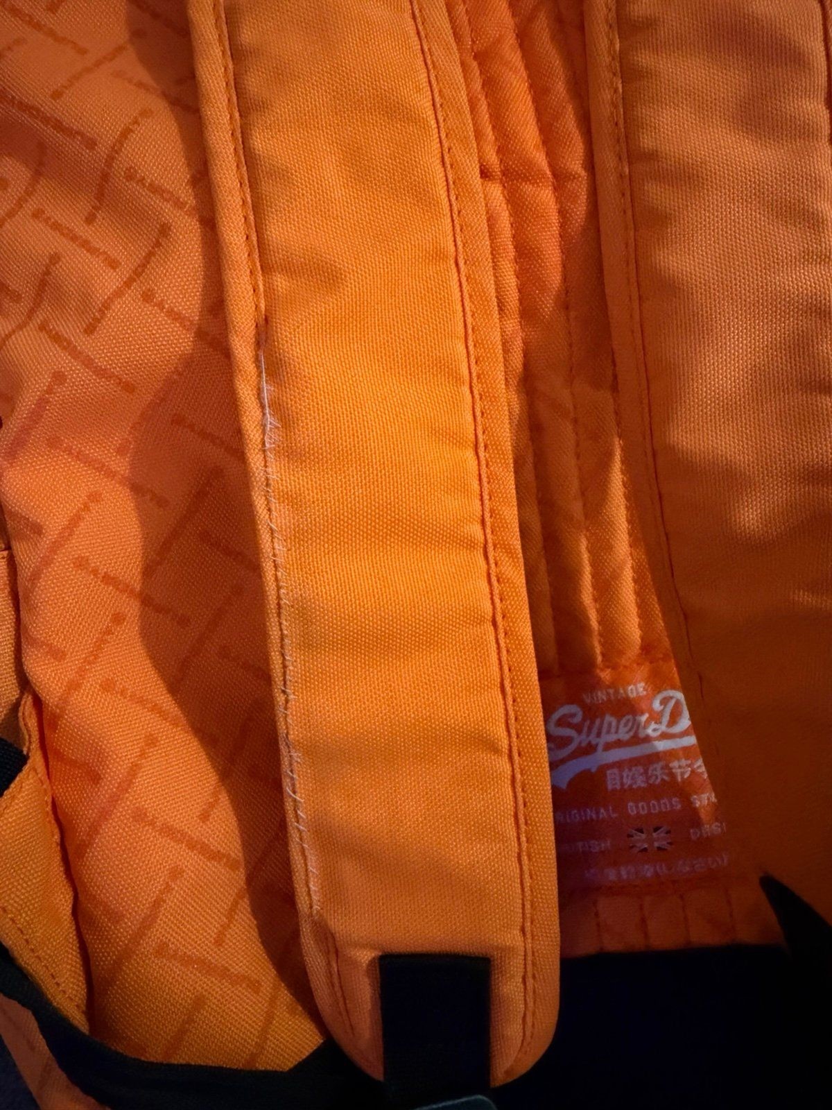 This orange Superdry Men Brand Logo Backpack features a high-build, embossed log